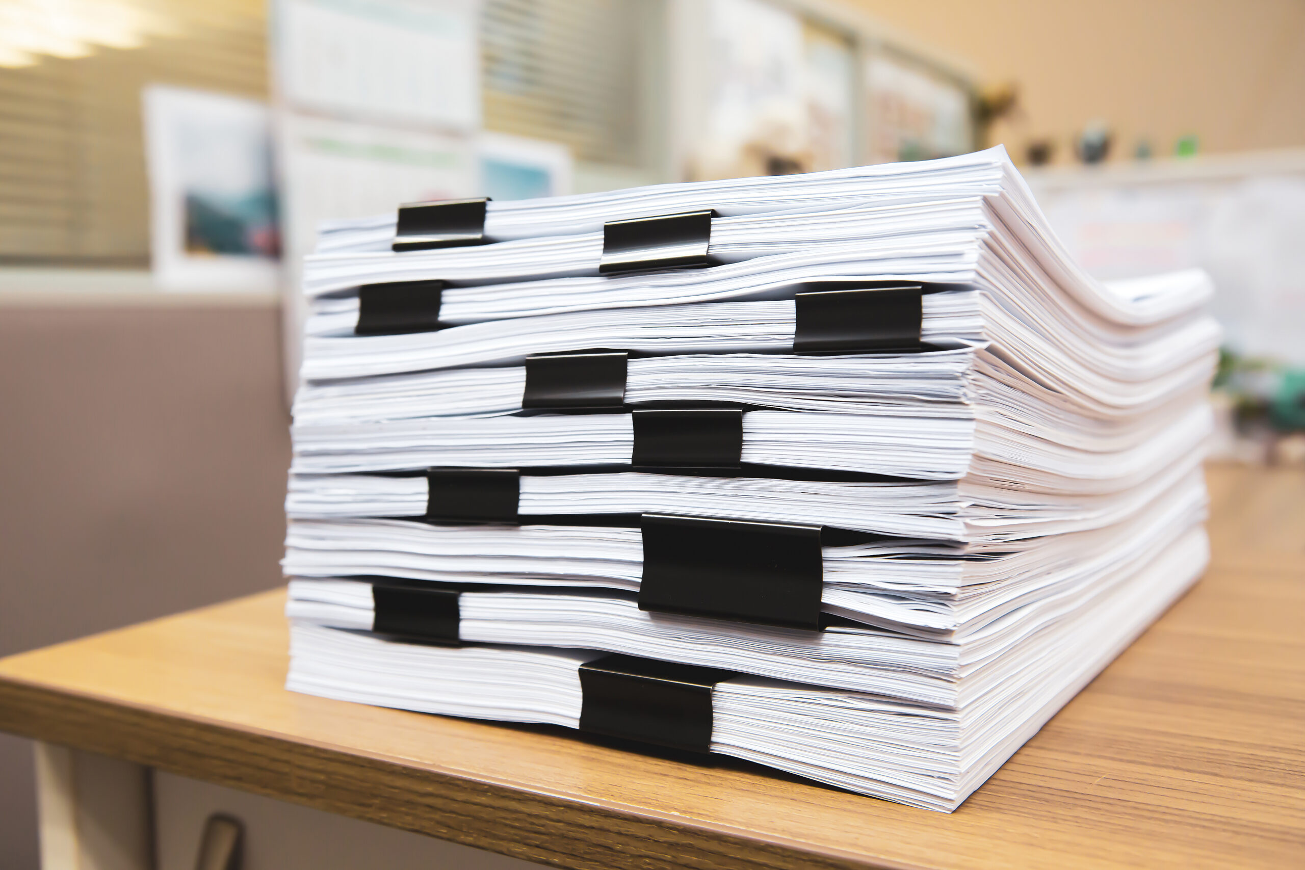 Pile of a lots paperwork report or printout document on desk office stack up.
